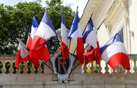 This image shows a group of French flags on a balcony.